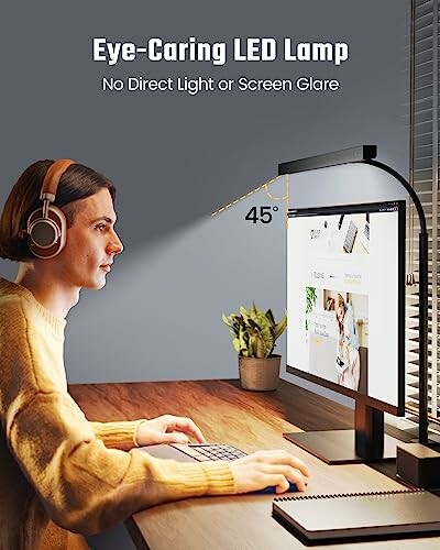 Person using eye-caring LED lamp while working on a computer